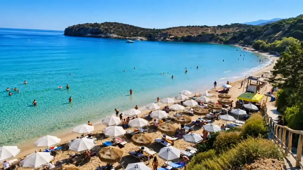 Sunbathers and straw umbrellas line Voulisma Beach, showing why East Crete is worth visiting.