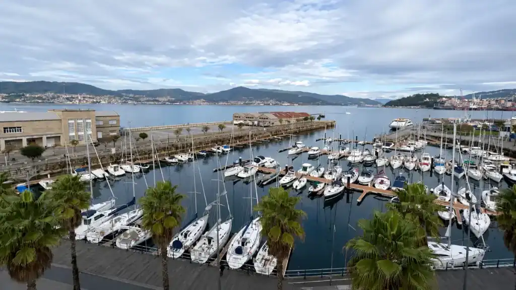 Sailboats moored at Vigo's Real Club Náutico marina with the Ría de Vigo stretching toward the hills in October on the Rías Baixas