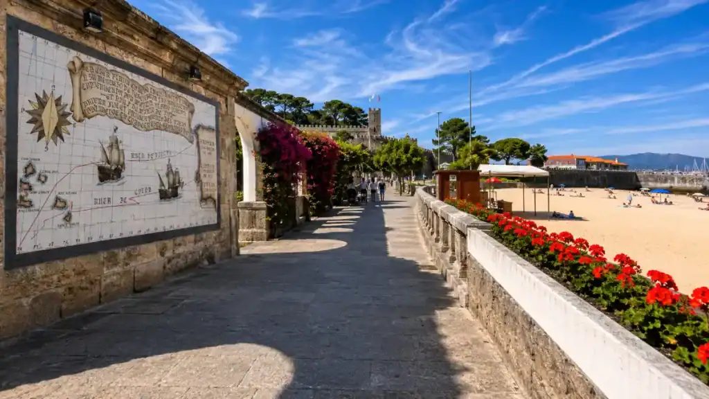 Tiled antique map mural beside a flower-lined promenade leading to the fortress at Baiona