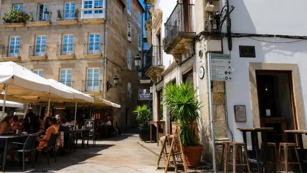 Outdoor restaurant tables and granite buildings on a road trip through Rías Baixas in Vigo's old town