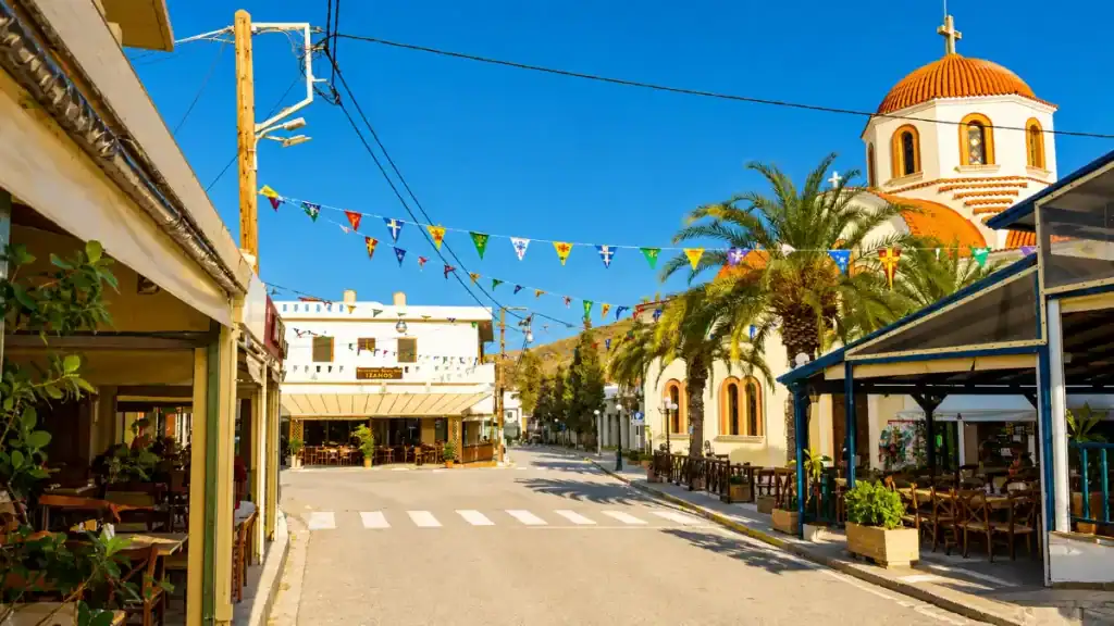 Tavernas and orange-domed church lining the main street through Sitia and Palekastro village