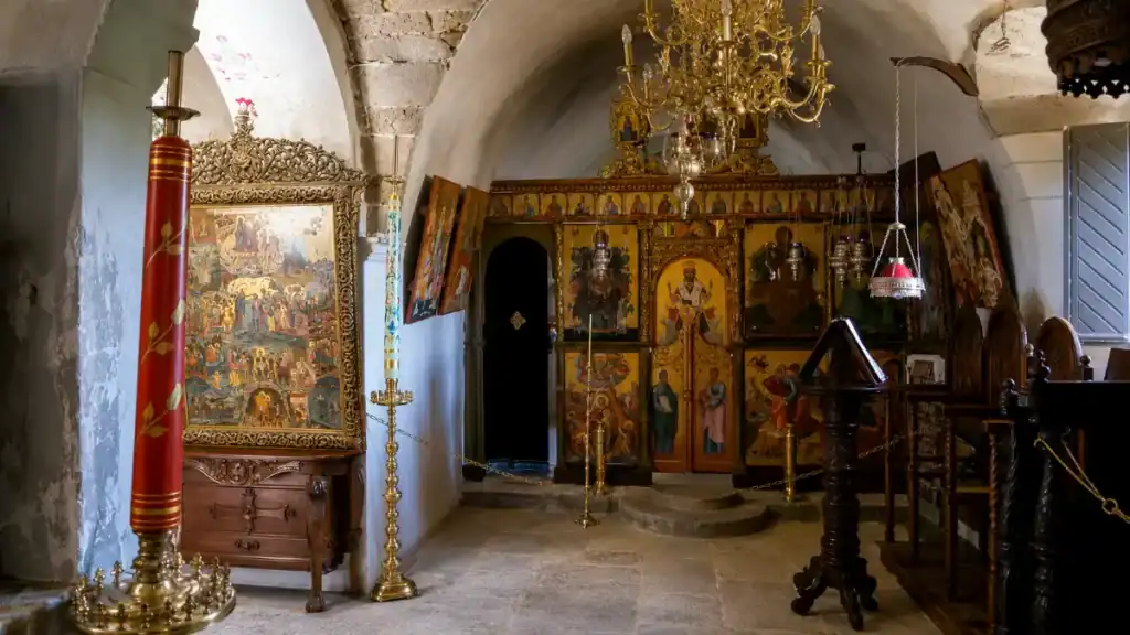 Painted iconostasis and brass chandelier inside the chapel at Toplou Monastery