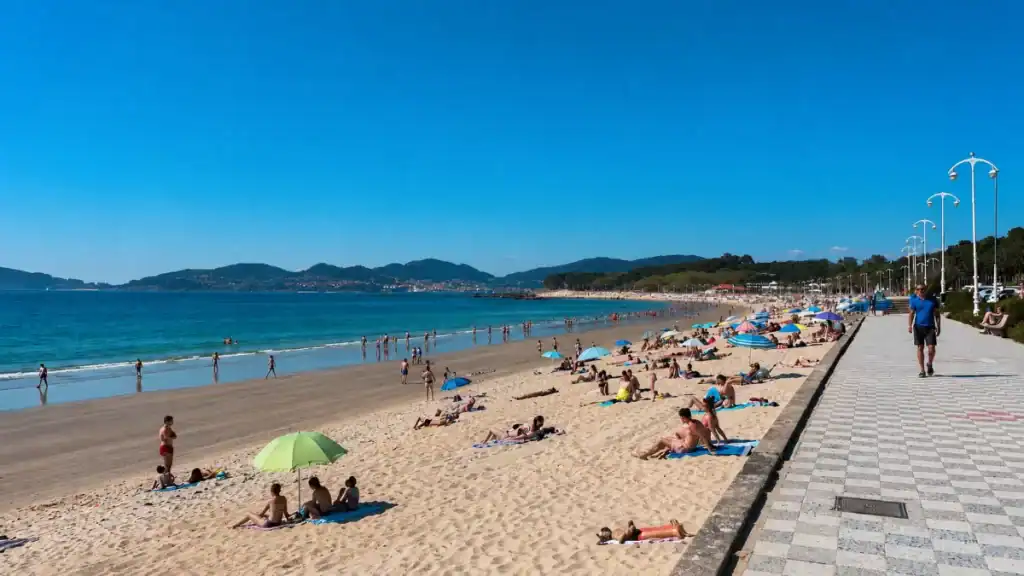 Sunbathers and colourful umbrellas on Samil Beach along the southern Galicia coast