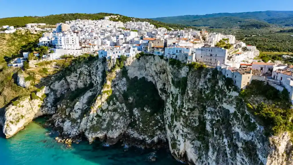 Whitewashed houses of Peschici old town crowning rugged limestone cliffs above the sea.