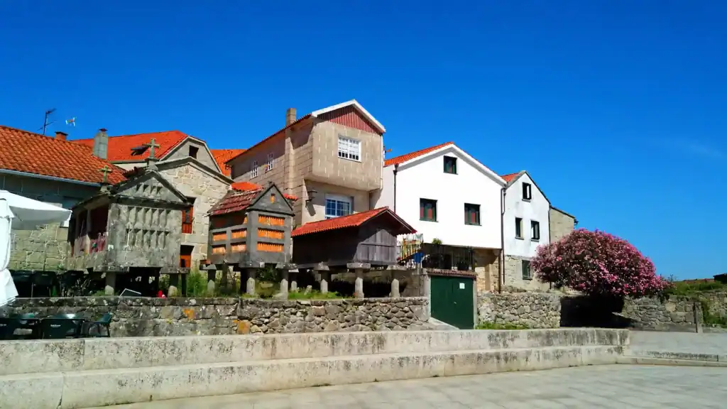 Stone hórreos and red-roofed houses along the Combarro waterfront to visit