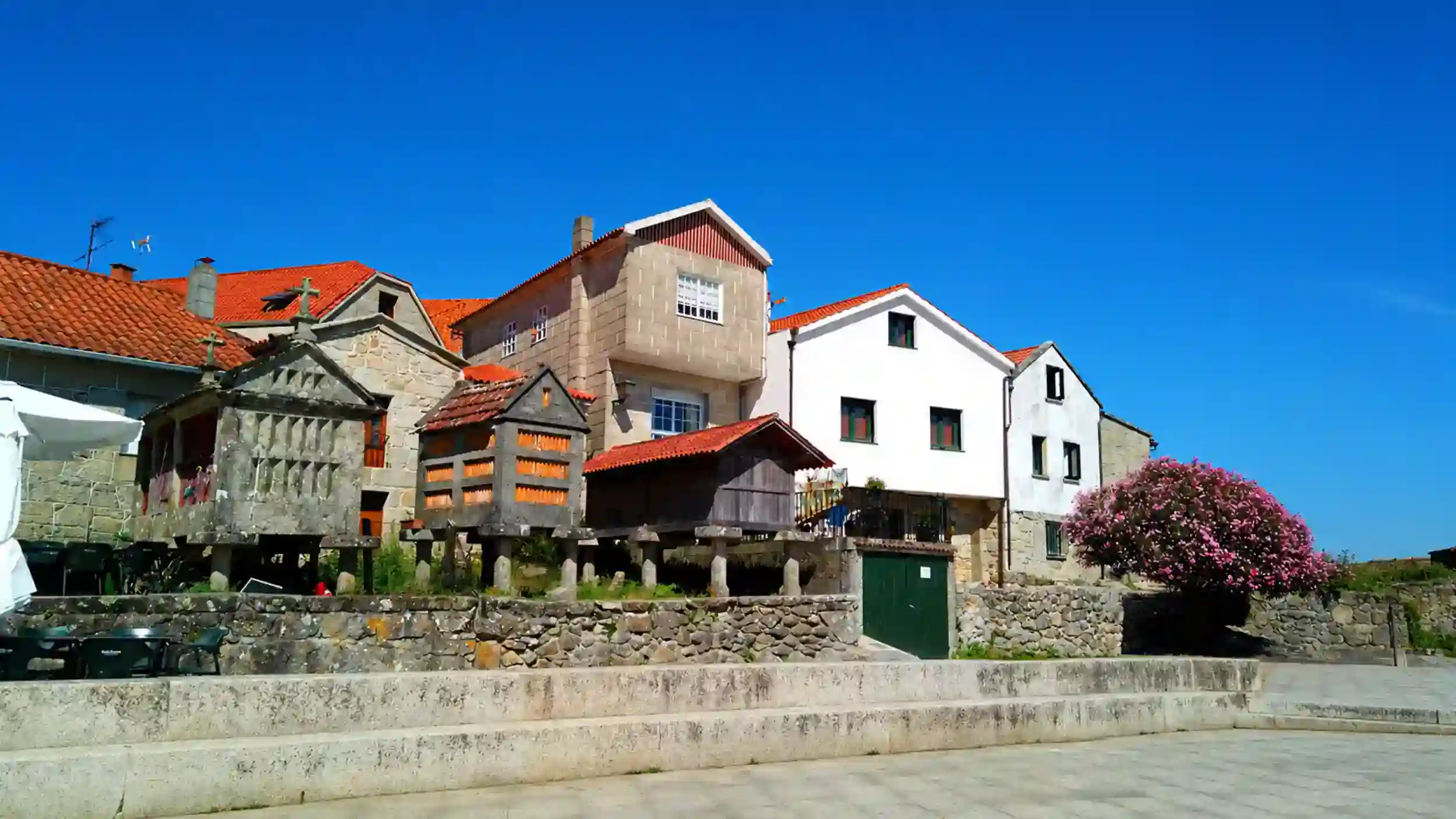Stone hórreos and red-roofed houses along the Combarro waterfront to visit