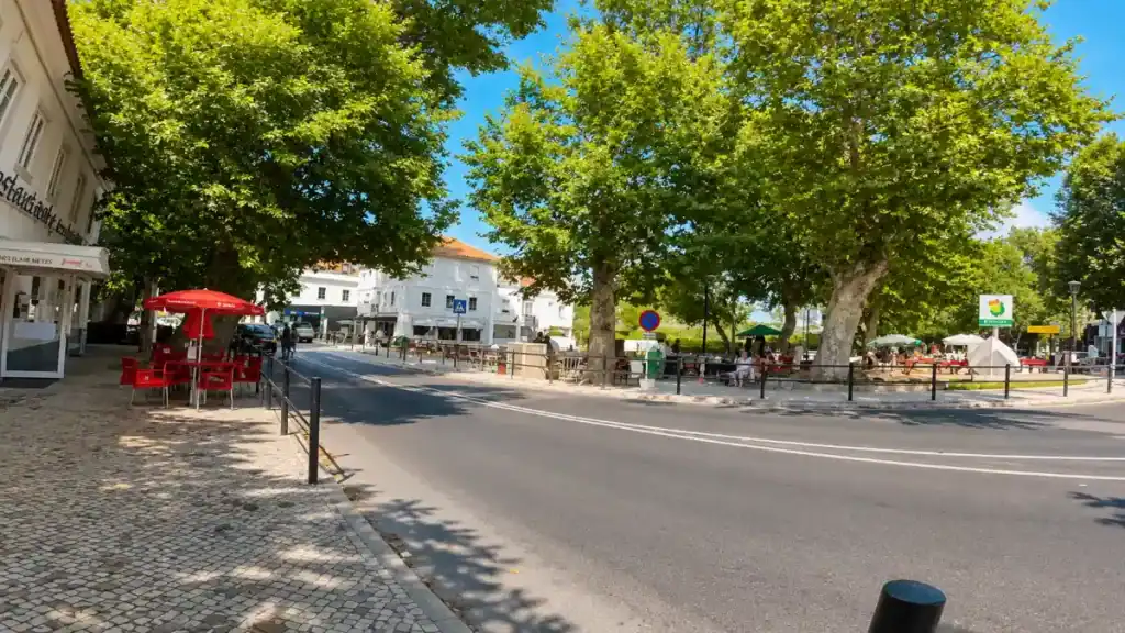 Plane trees shade a cafe terrace and crossroads in central Colares.