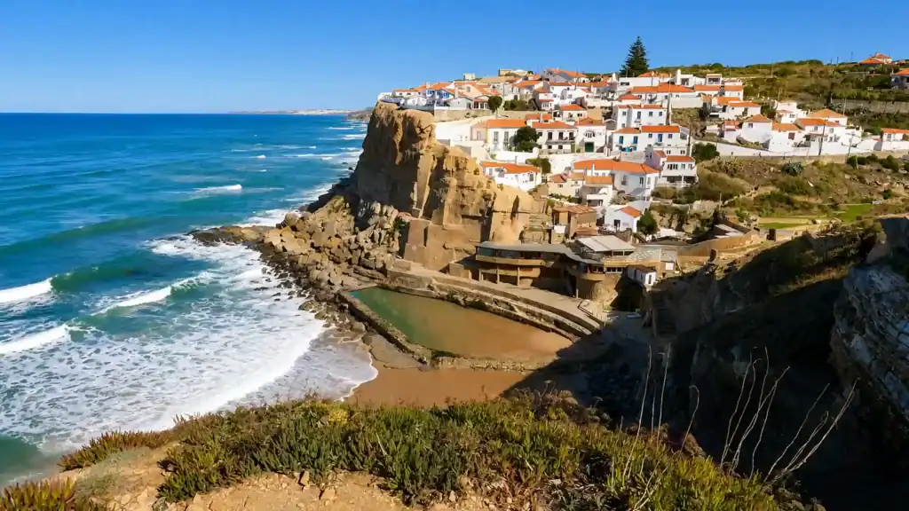 White-washed village of Azenhas do Mar clinging to Atlantic cliffs above a natural rock pool