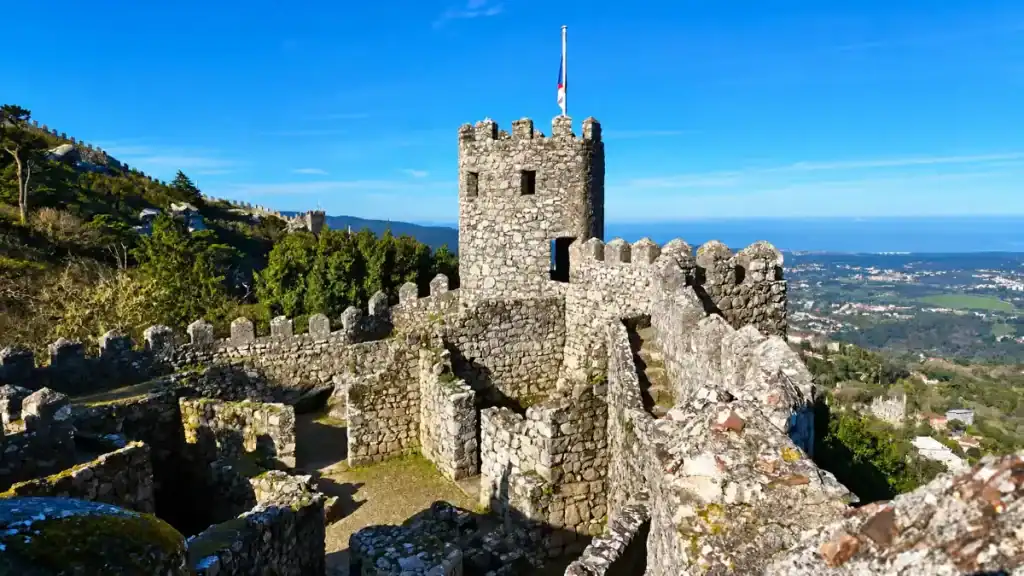 Castelo dos Mouros ancient stone ramparts and flag tower overlooking the Sintra valley and Atlantic coastline