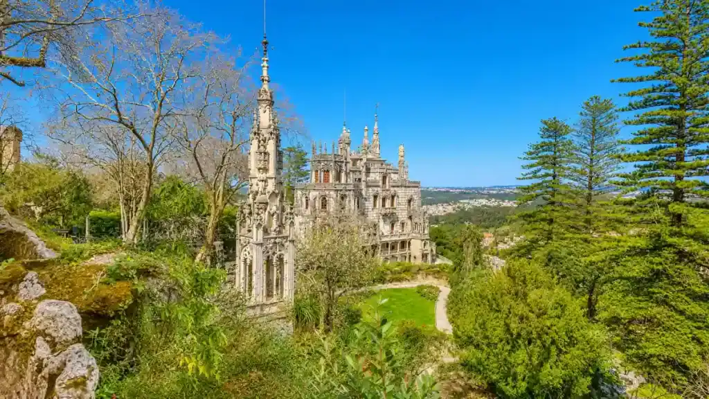 Quinta da Regaleira Gothic chapel and palace spires rising above terraced gardens and woodland