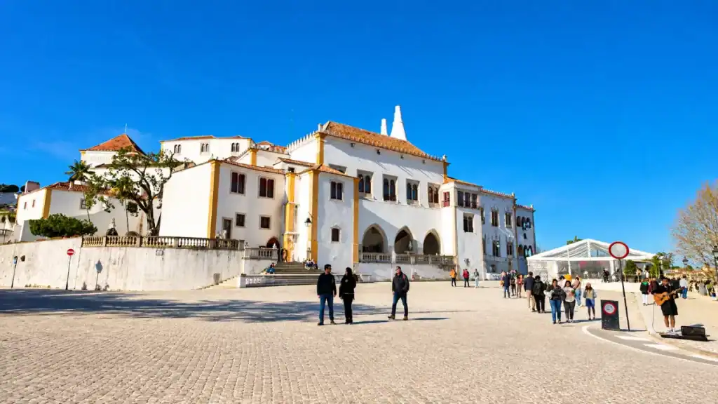 Sintra National Palace white facade and twin chimneys facing the cobbled town square, among the beautiful places around Sintra