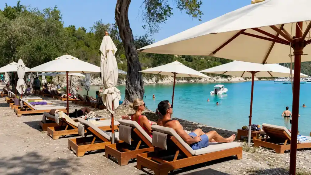 Rows of sun loungers and umbrellas line the pebble shore at Harami Beach.