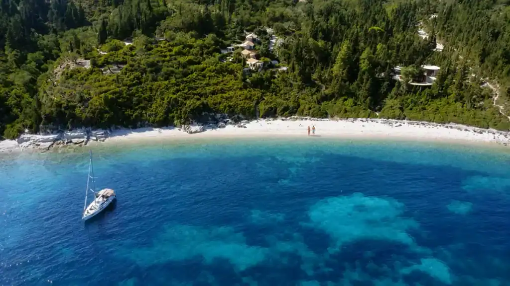 A sailboat anchors off the pale crescent sand of Kipiadi Beach.