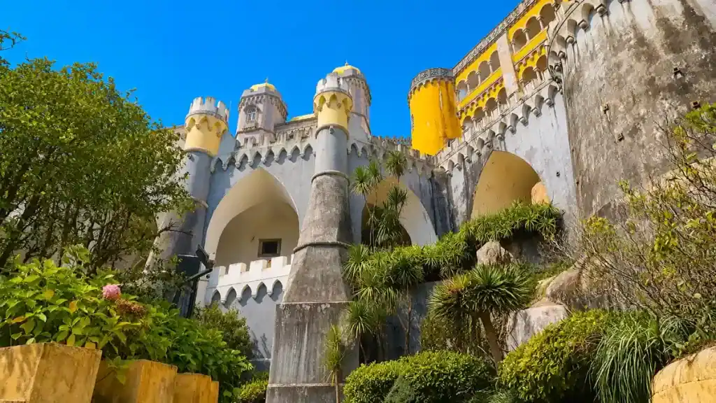 Gothic arched terraces and conical turrets rise above Pena Palace's garden walls