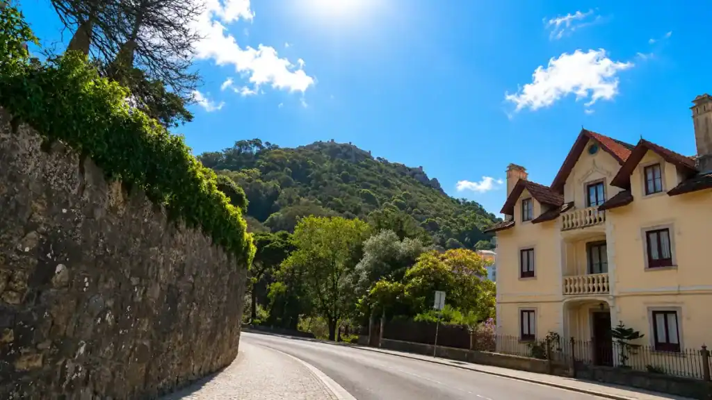 Moorish Castle ramparts crown a wooded hill above a quiet Sintra street