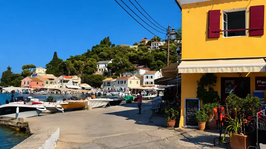 Small boats line the quay beneath pastel houses in Loggos.