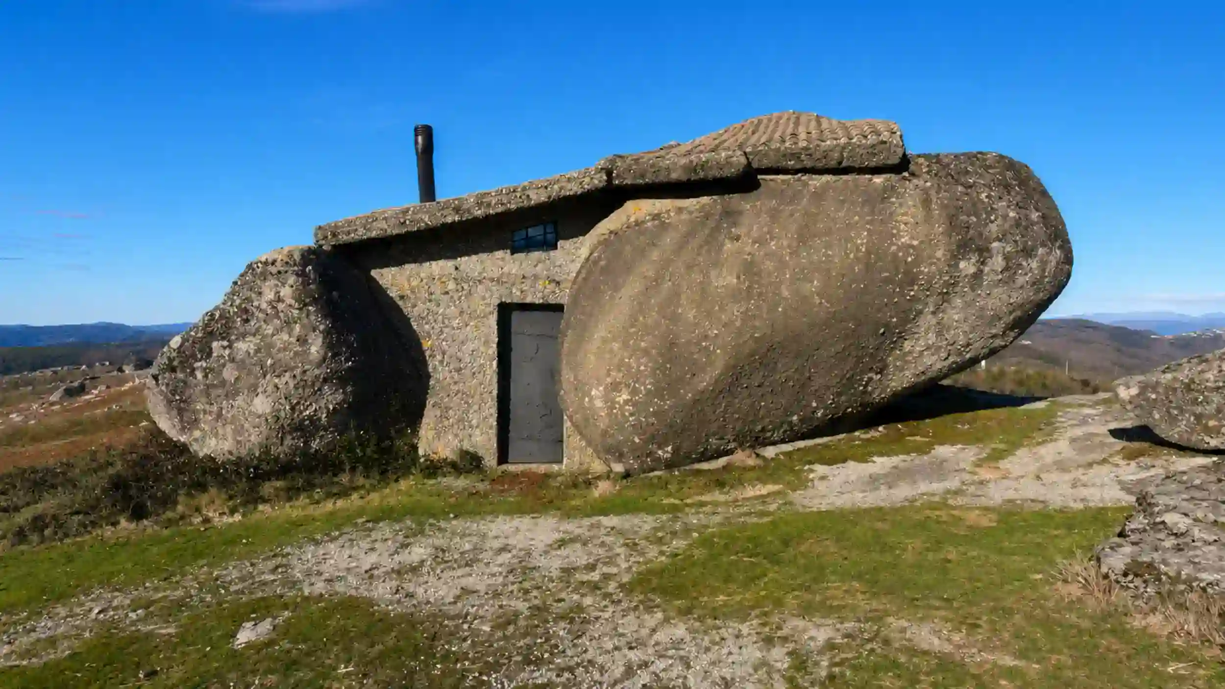 Casa do Penedo wedged between massive granite boulders near Fafe.