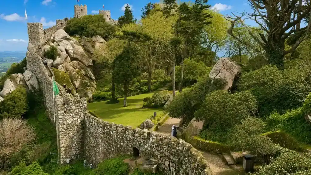 Stone ramparts of the Castelo dos Mouros wind along a tree covered ridge.