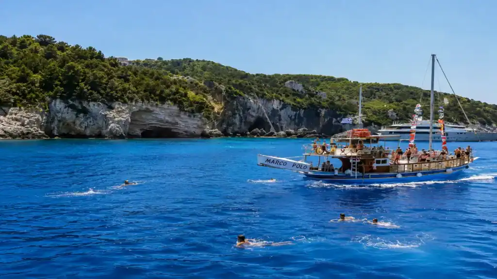 Passengers swim beside an excursion boat near the caves of Antipaxos.
