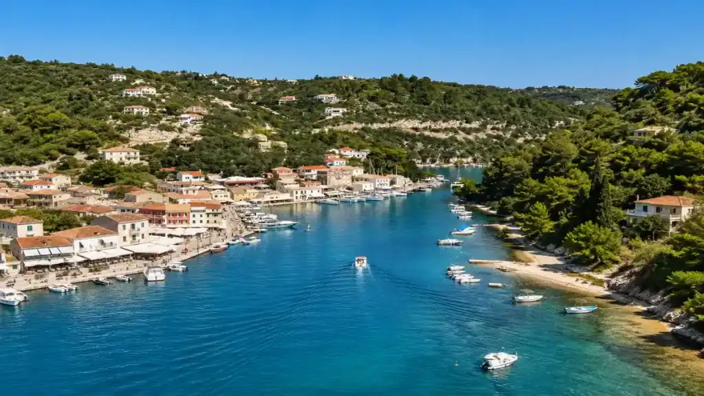 A small boat cruises the narrow inlet leading into Loggos village harbour.