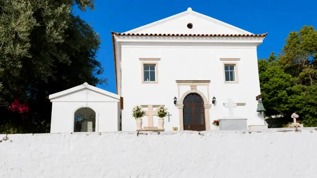 Whitewashed facade and stone crosses at Agios Spyridon church.