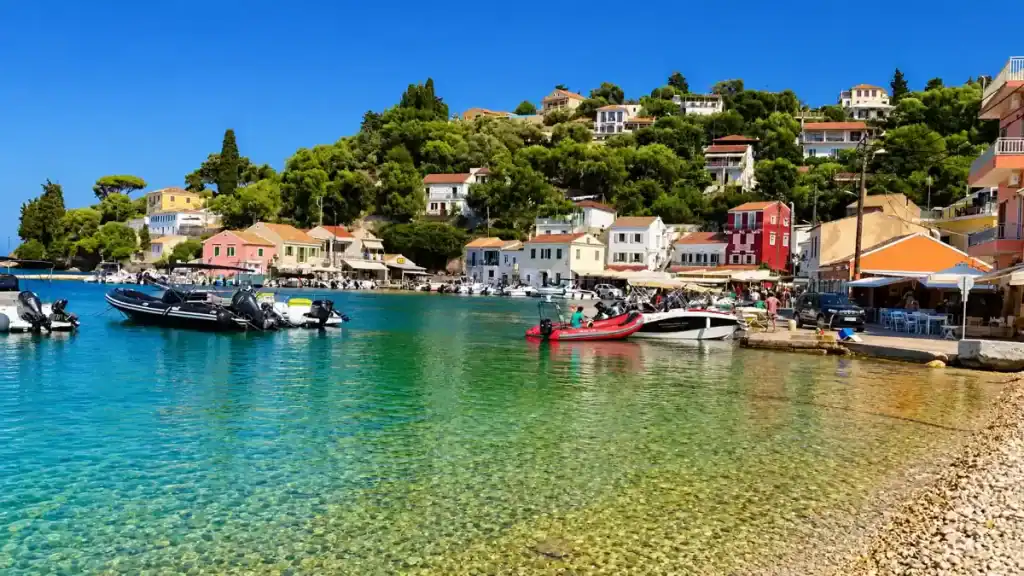 Fishing boats moored in the clear green waters of Loggos harbour.