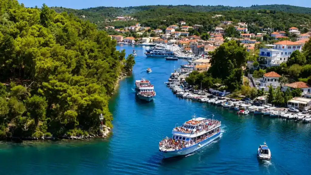 Excursion boats enter the pine-lined channel toward Gaios past Panagia islet.