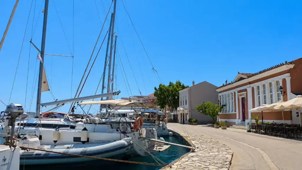 Sailboats moor beside the neoclassical town hall along Gaios waterfront promenade.