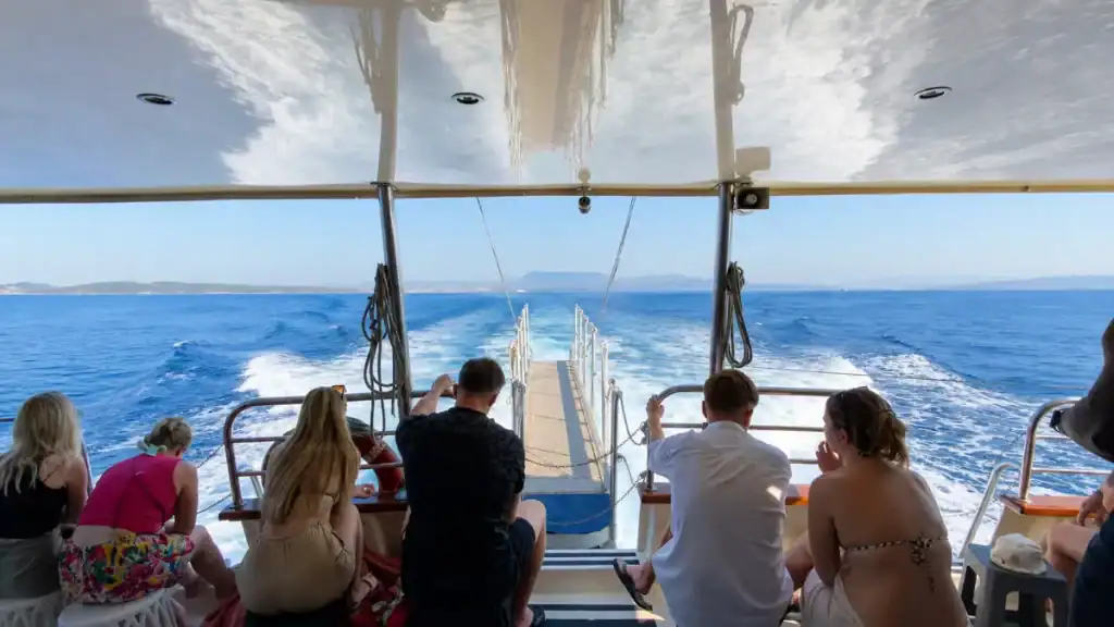 Passengers watch the wake from a ferry crossing between Corfu and Paxos.