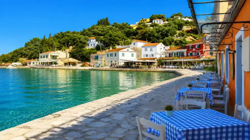Blue checked tables line the stone quay overlooking Loggos harbour.