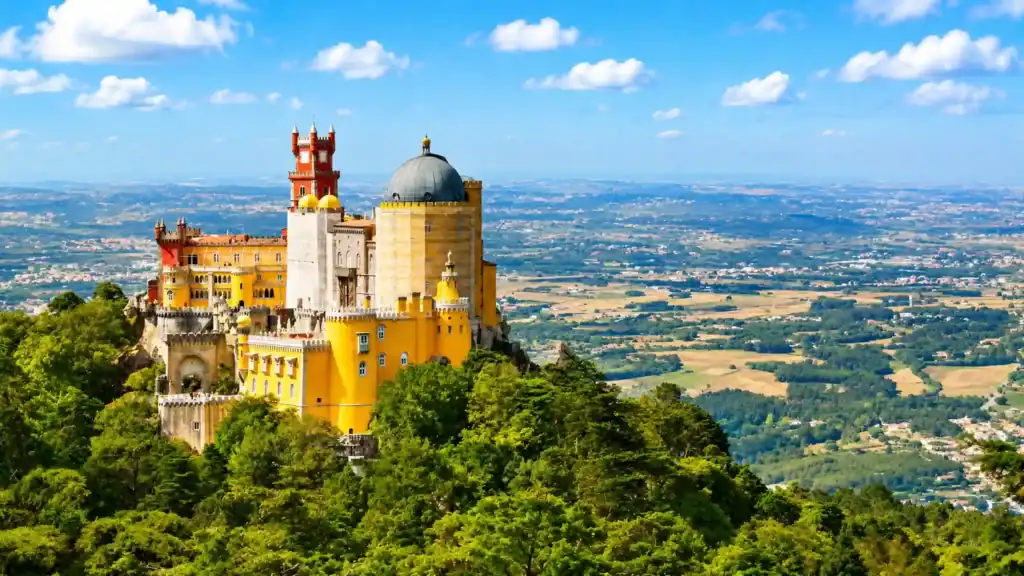 Pena Palace rising above forested hills with sweeping views of places around Sintra