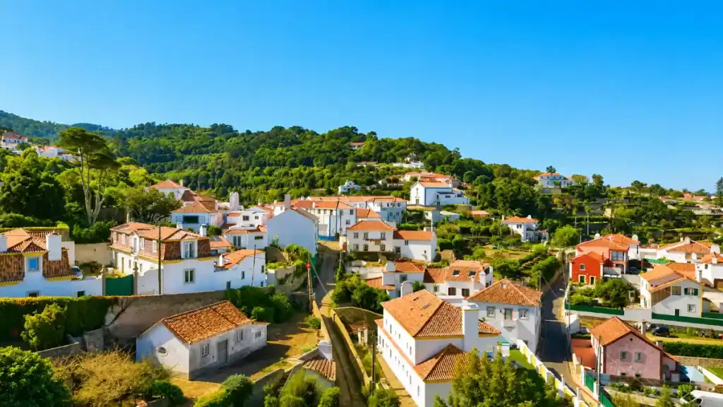 White-walled houses with terracotta roofs spread across the hillside village of Penedo