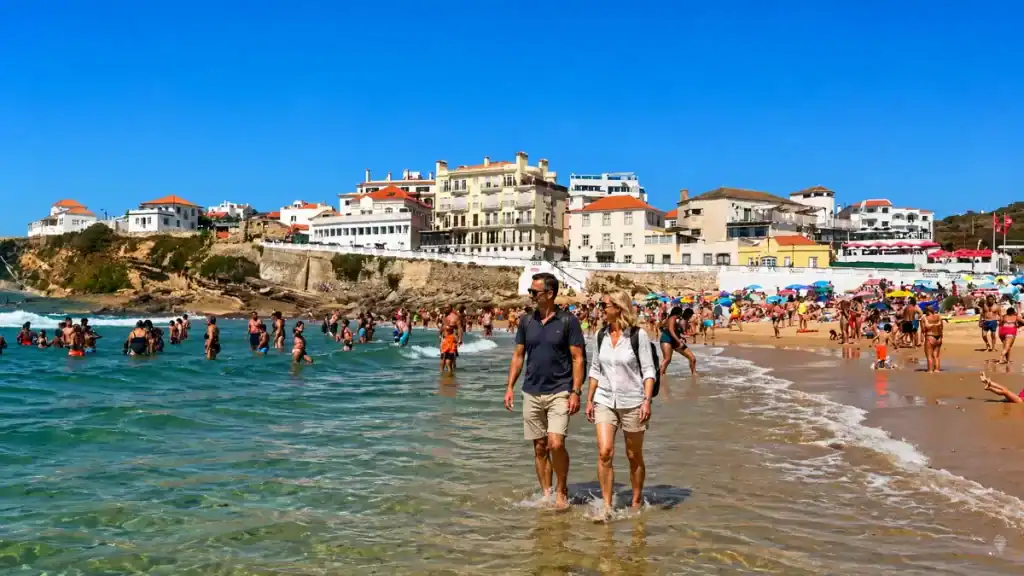 Sunbathers and swimmers crowd the shoreline at Praia das Maçãs near Sintra.