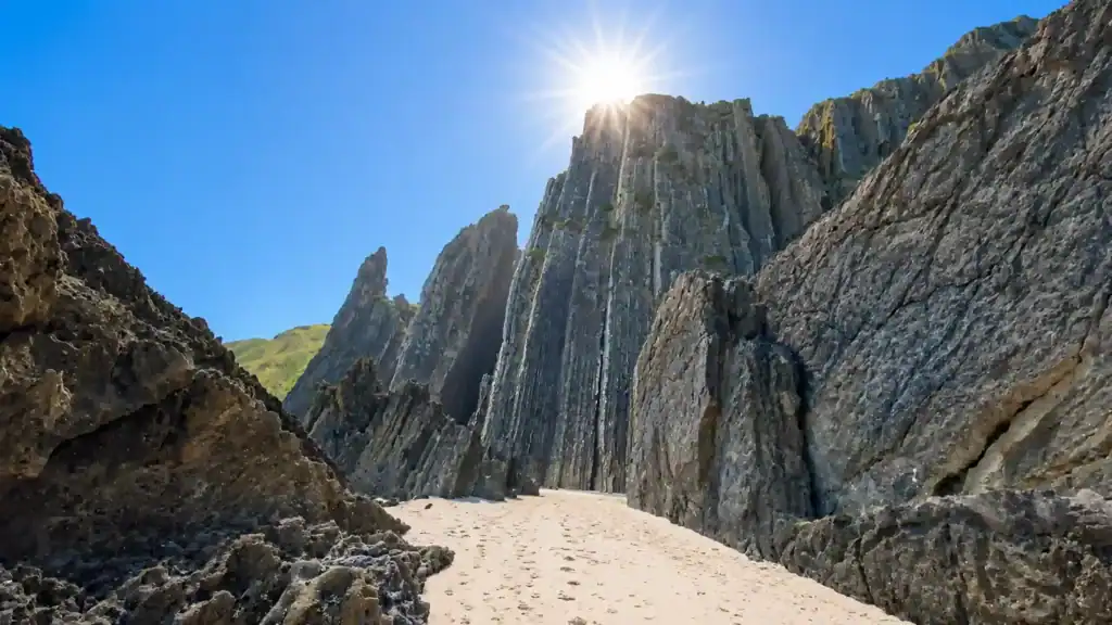Jagged rock formations flanking a sandy passage at Praia Grande