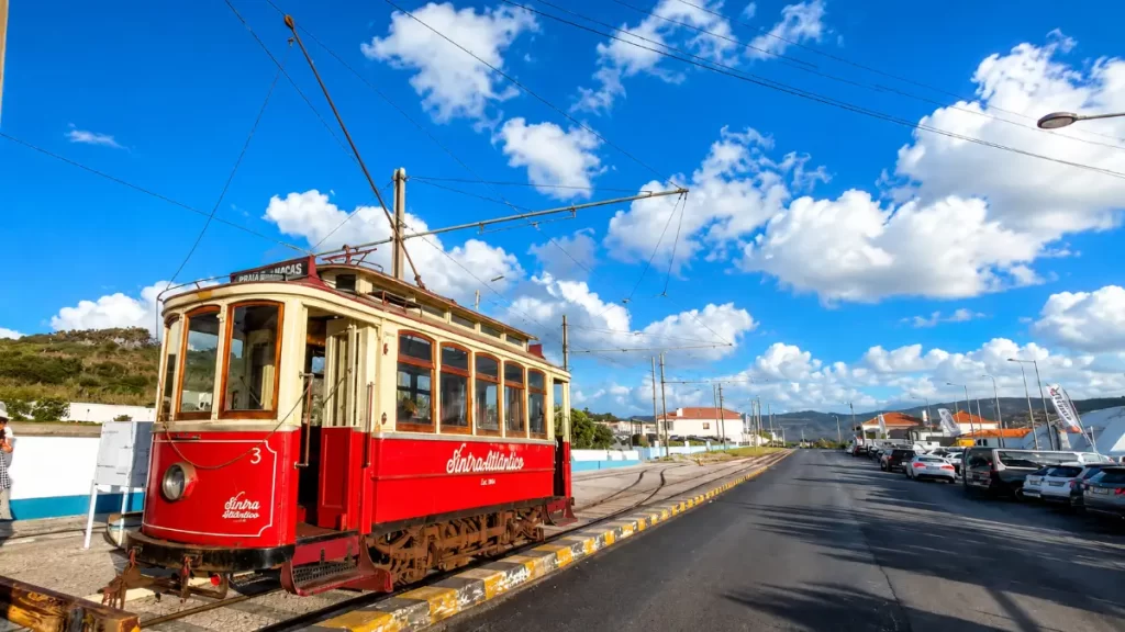 Vintage red Sintra Atlântico tram bound for Praia das Maçãs on tracks.