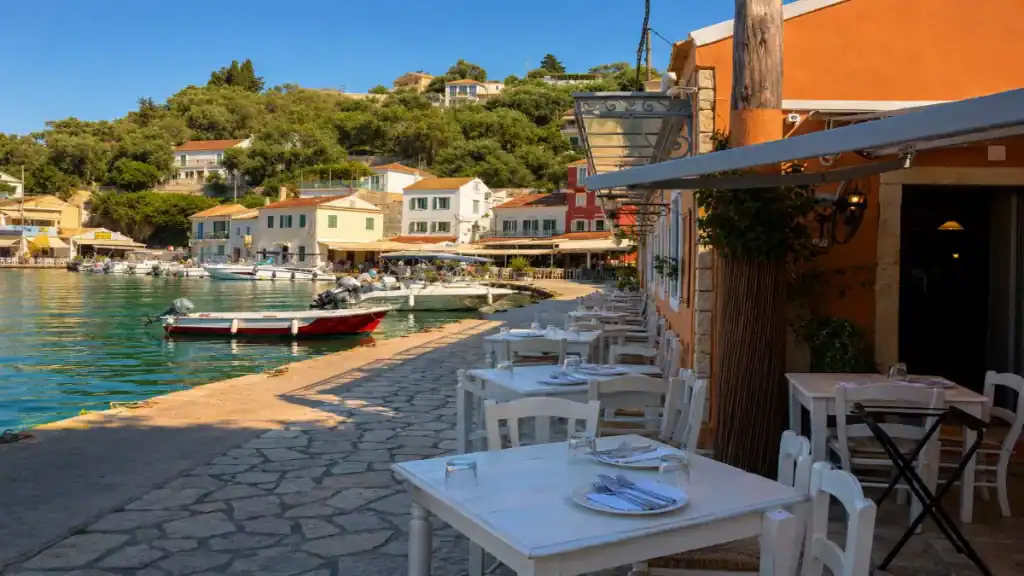 White-clothed tavern tables line the stone quay overlooking Loggos harbour.