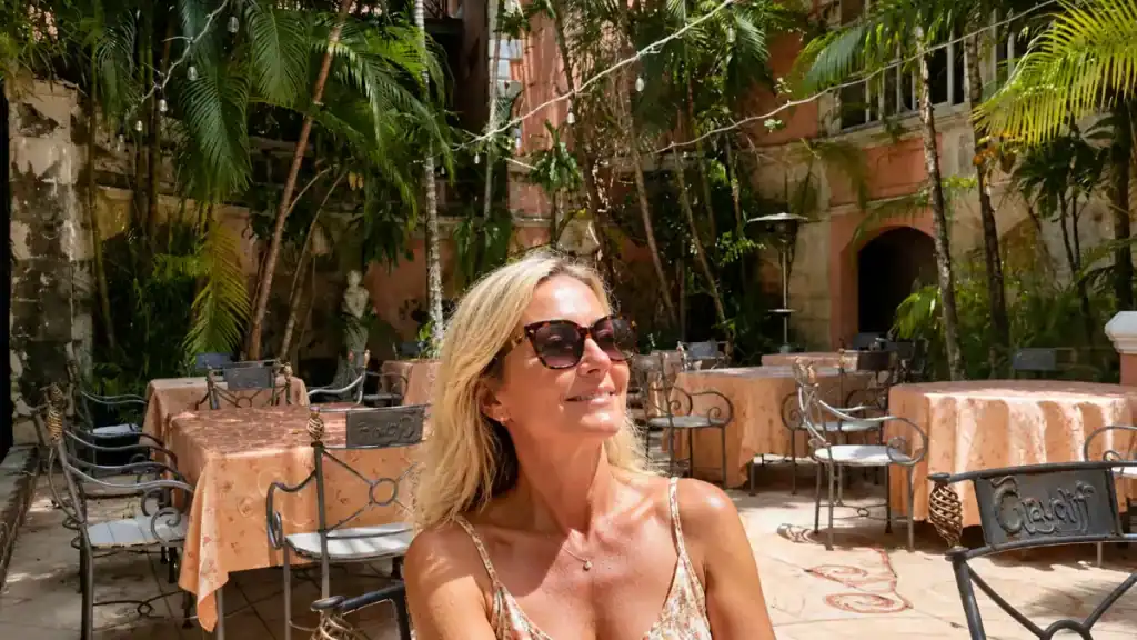 Woman relaxes in the palm shaded courtyard at Graycliff restaurant