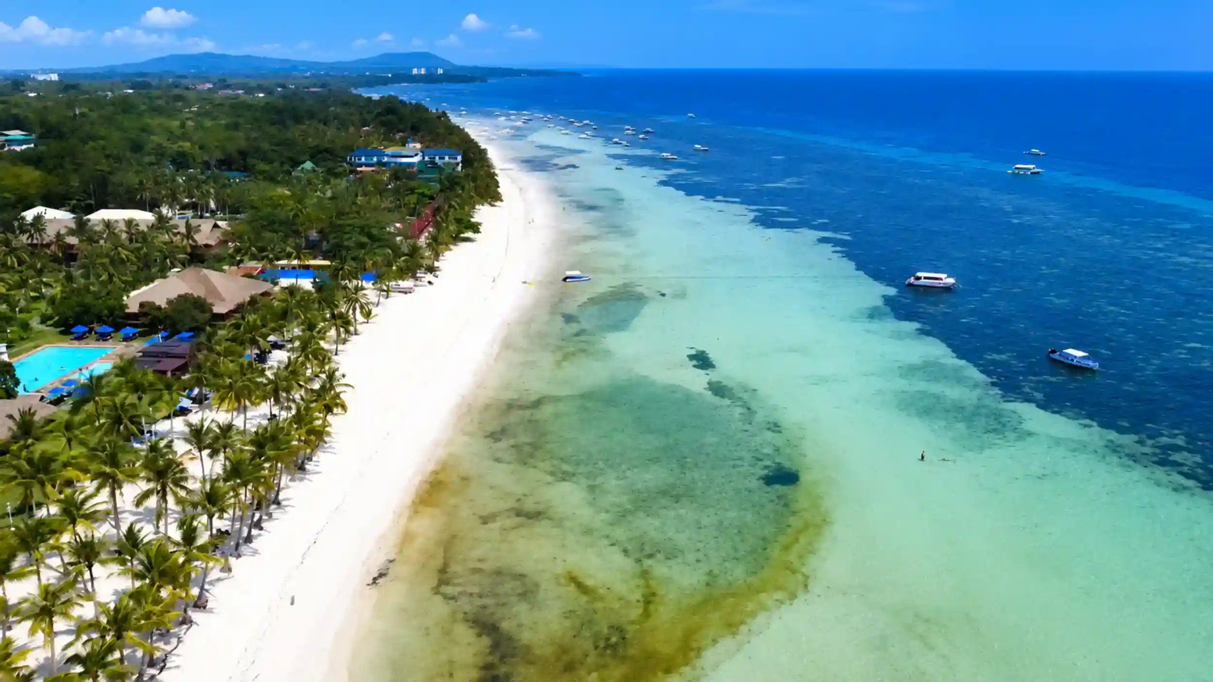 Aerial view of Dumaluan Beach's turquoise shallows, a top stop on any best Bohol itinerary