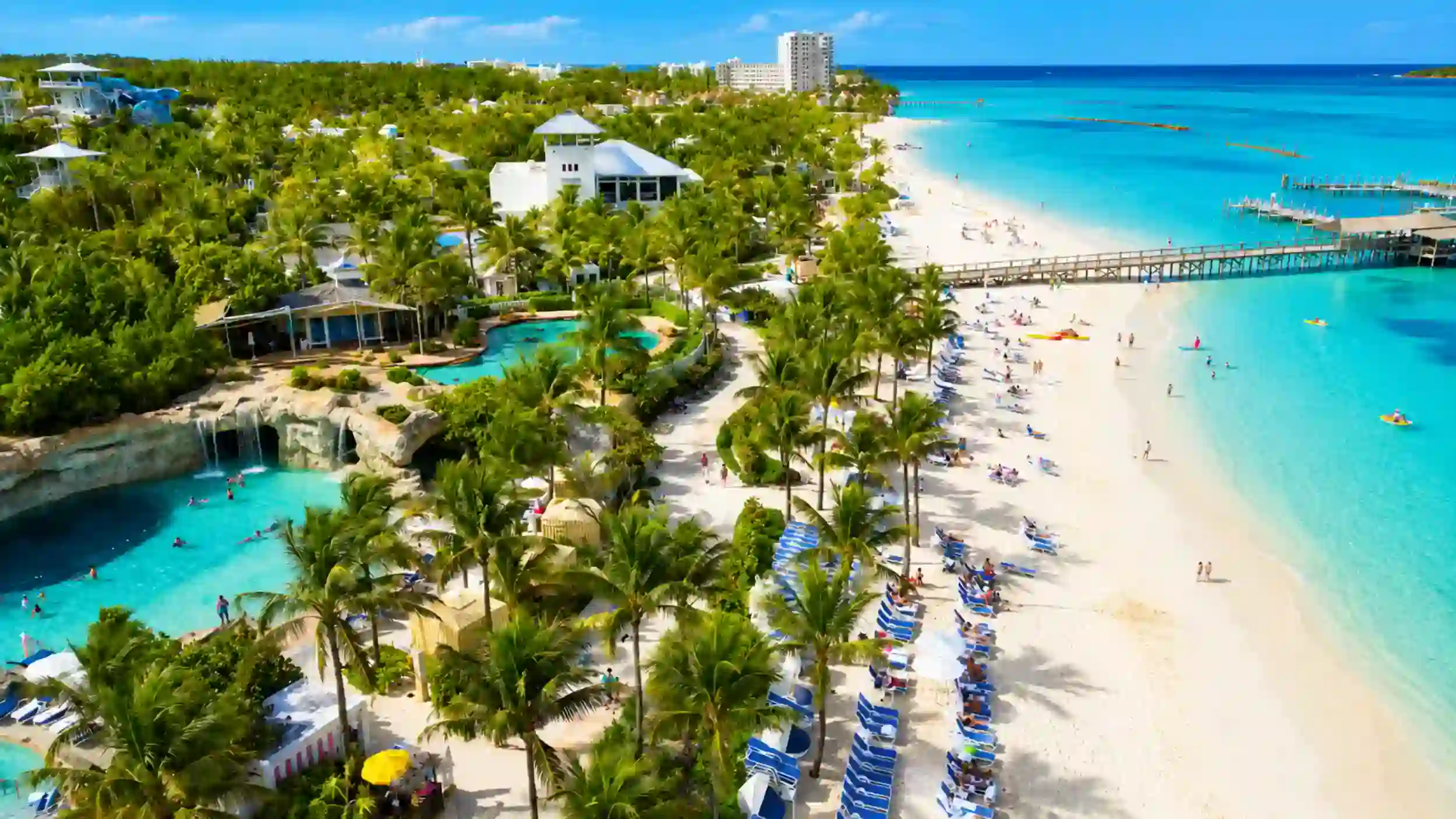 Sunbathers pack a lively beach, a clear sign of the best time to visit Nassau