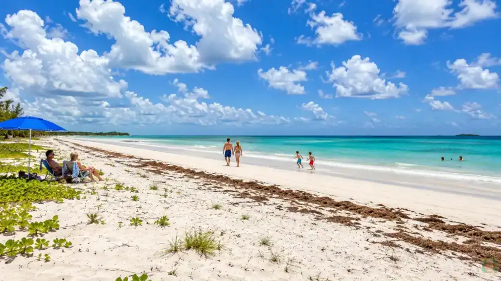 Families relax and stroll along a wide stretch of Grand Bahama beach