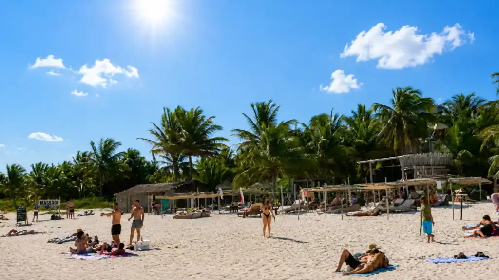 Sunbathers relax on a palm-fringed Tulum beach club, popular with visitors weighing how many days in Tulum.