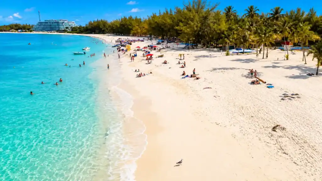 An aerial view captures swimmers and sunbathers along Cable Beach's wide stretch of white sand.
