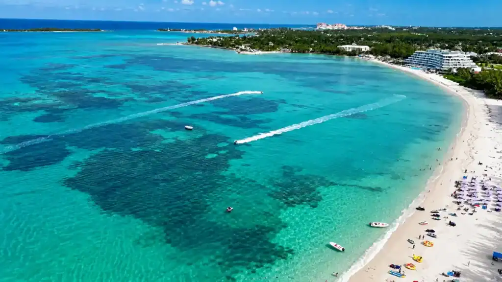 Jet skis carve wakes across the coral patterned water off Cable Beach