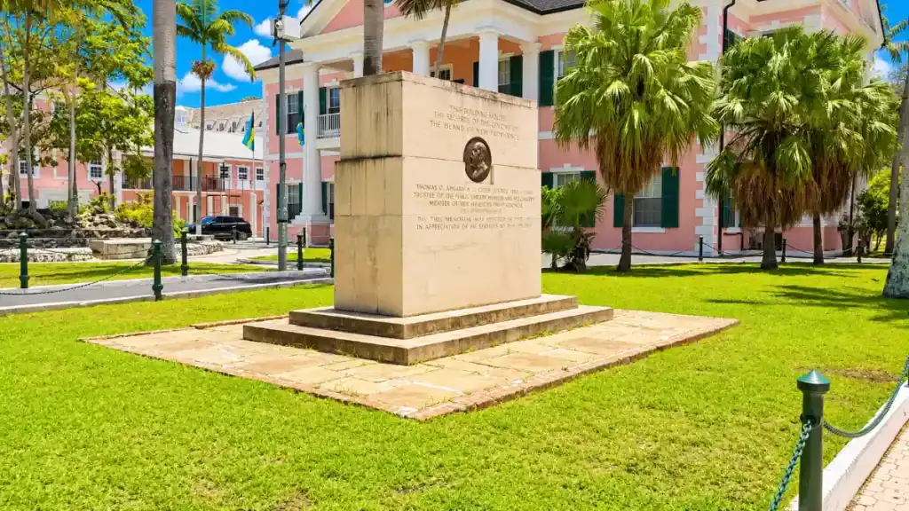A stone memorial stands on the lawn outside the pink colonial-style Public Records Office in downtown Nassau.
