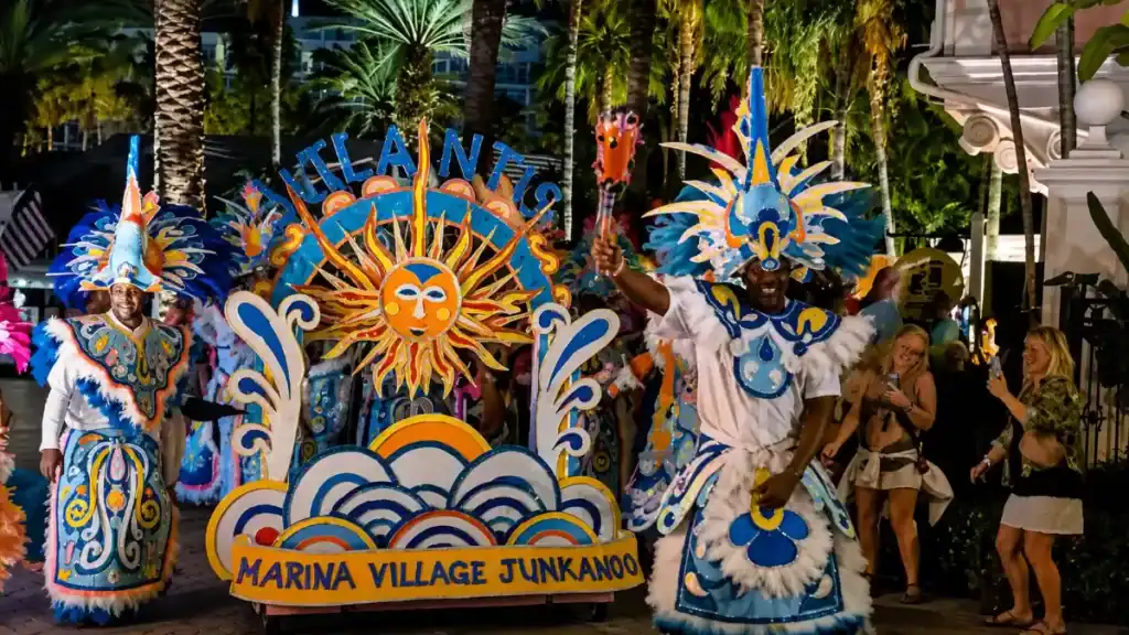 Costumed performers march in a vibrant Junkanoo parade near Nassau's marina