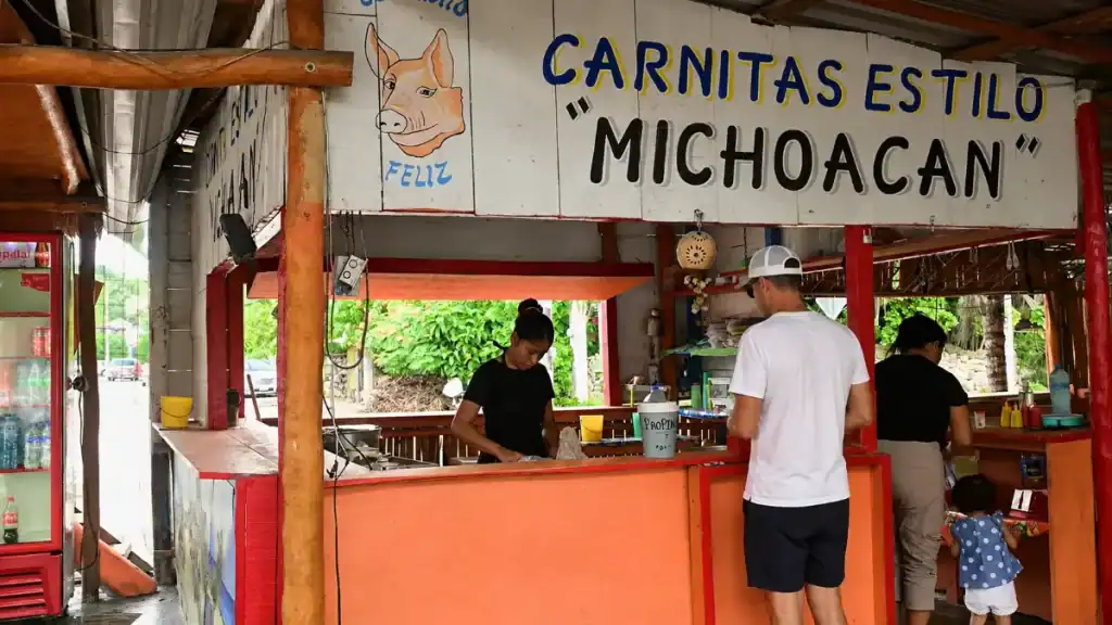 Roadside carnitas stand serving customers near Tulum's main highway