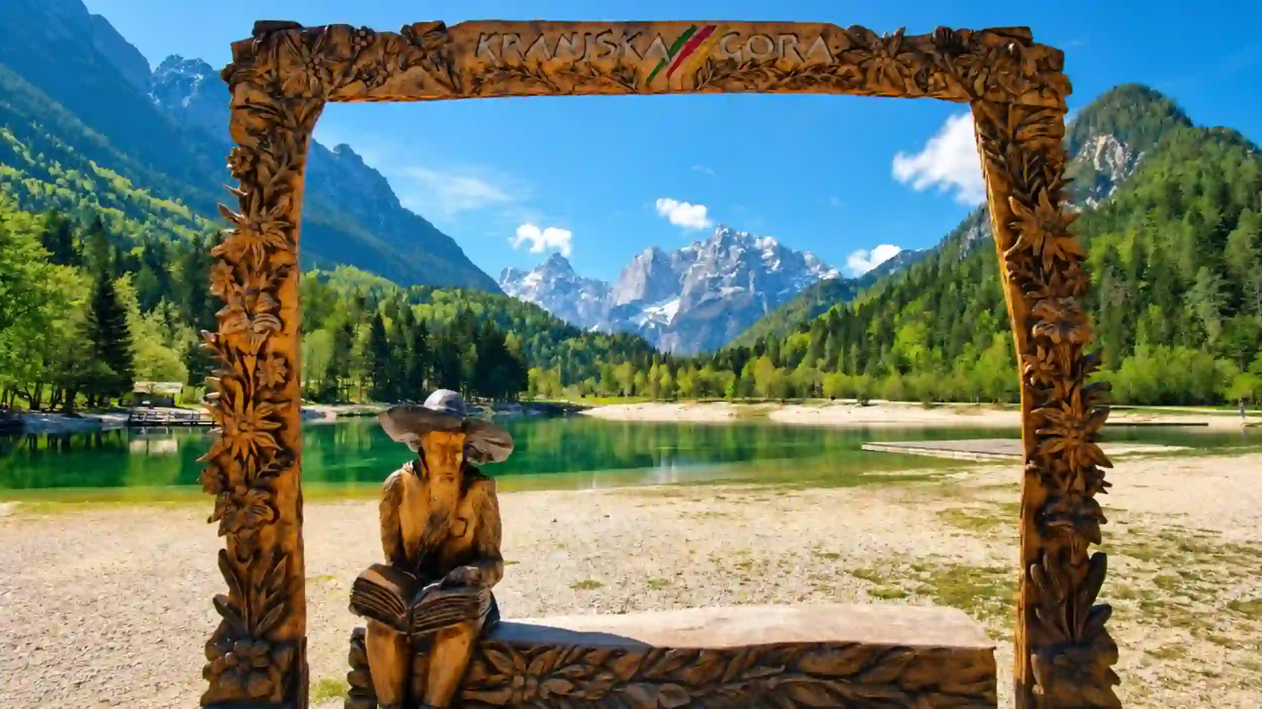 Carved wooden frame with Kranjska Gora sign overlooks Lake Jasna, near where to stay in Kranjska Gora