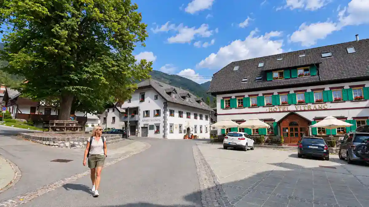 Woman walks through Podkoren square, a quiet base for where to stay in Kranjska Gora