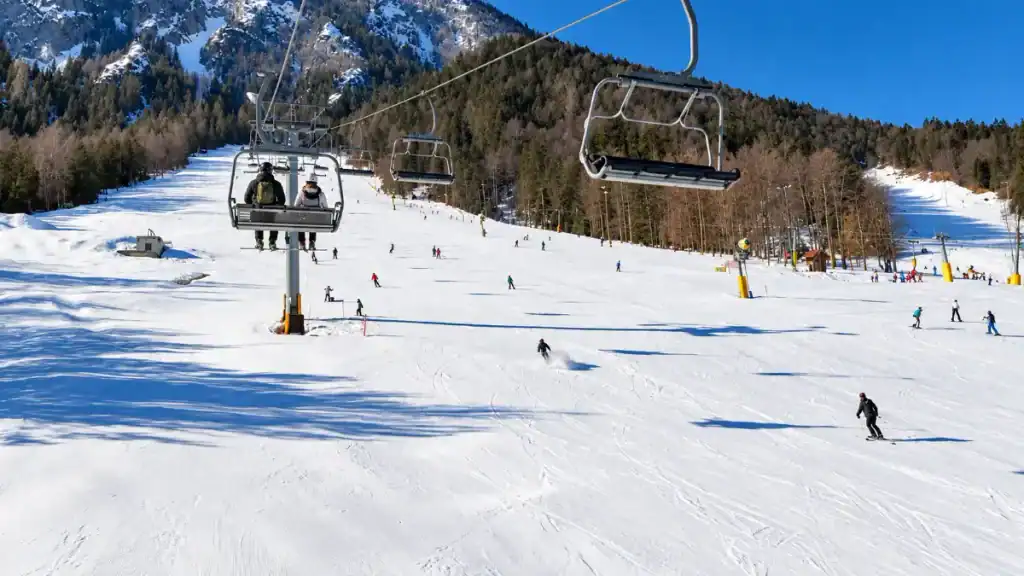 Skiers descend below a chairlift on the slopes of Vitranc above Kranjska Gora