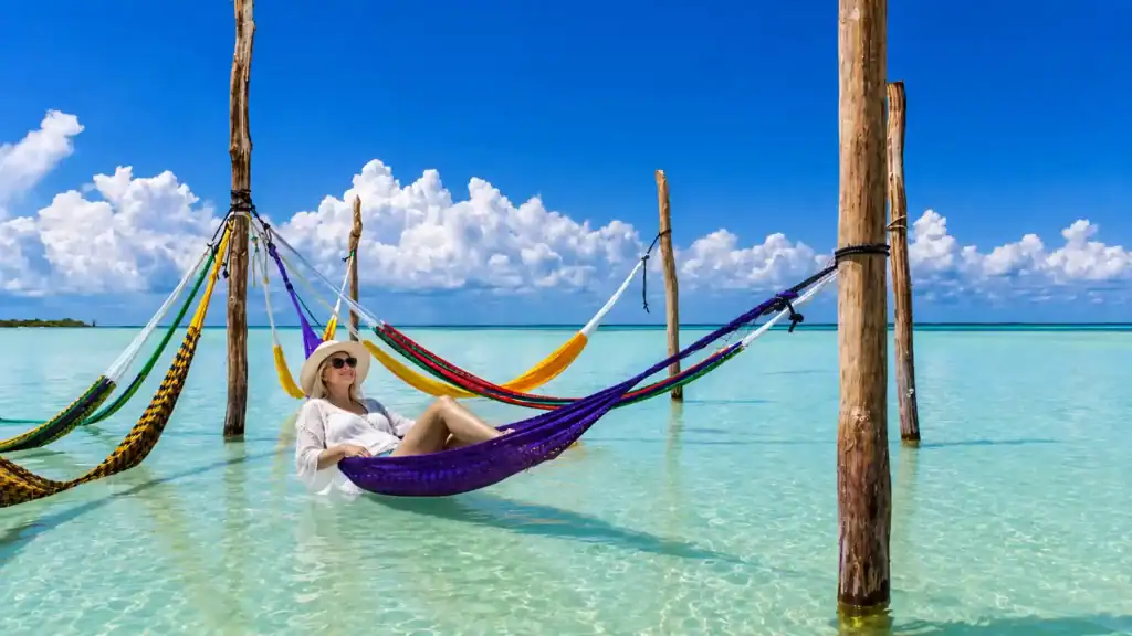Woman relaxing in an overwater hammock, a classic Holbox day trip highlight